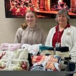 MaKayla Allmaras (left) and LaVonne Matthews, Department VA&R Chairman, shown with tie-blankets designed, assembled, and donated by the Philanthropy and Youth group from Northern Cass High School.