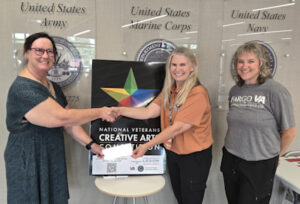Carol Wolf, Department VA&R Chairman (left), presents a check to volunteer services personnel in support of the North Dakota Creative Arts Festival held at the Fargo VA on August 21-22, 2025.