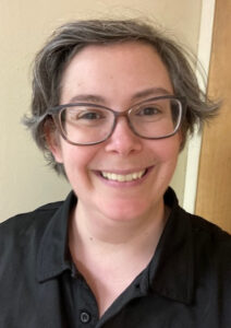 lady with brown hair and glasses and black shirt on beige backgroundLatoya Carpenter - Vice President