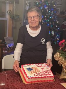 lady with silver hair holding a years of service cake